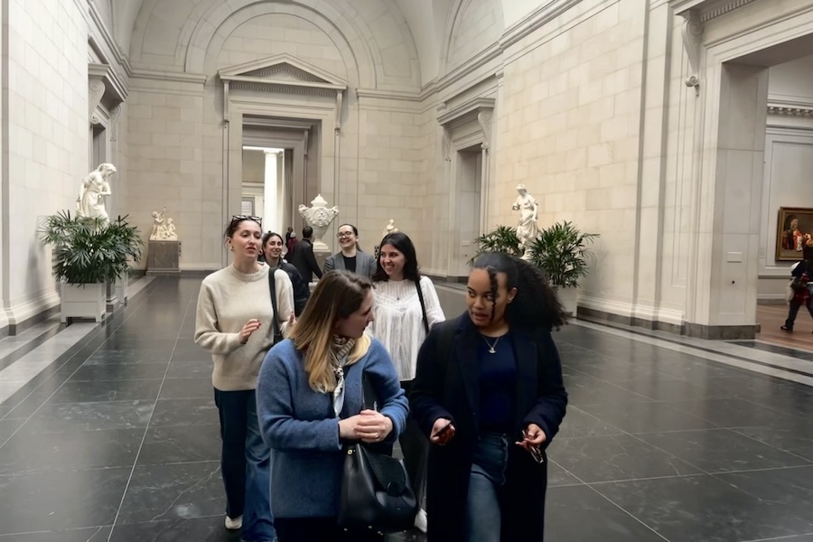 A tour guide leads a group through the National Gallery of Art.