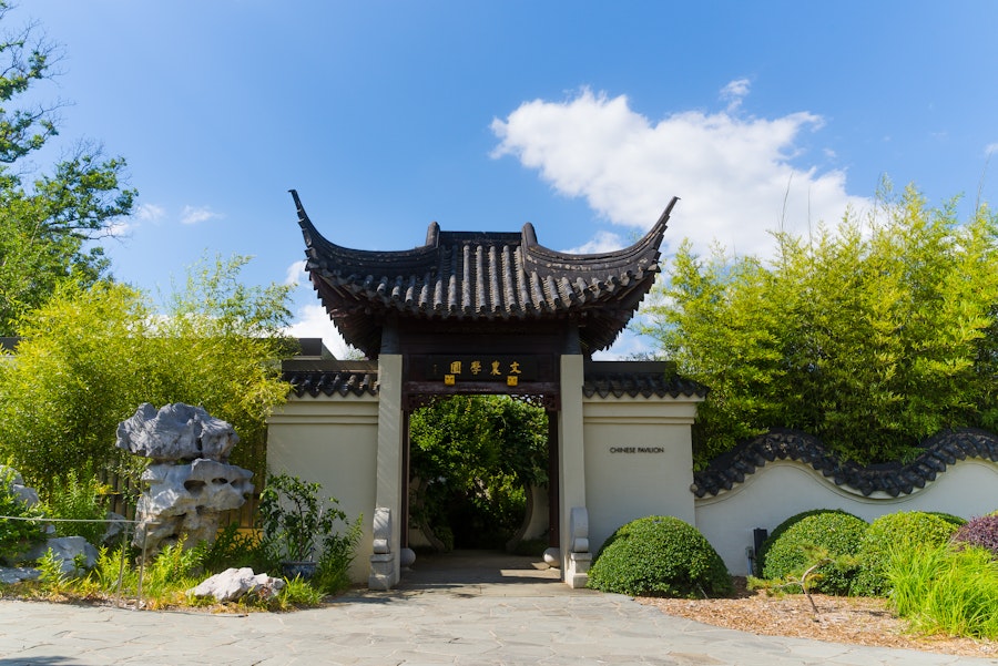 Traditional Chinese gate at the National Arboretum framed by bamboo and garden greenery.